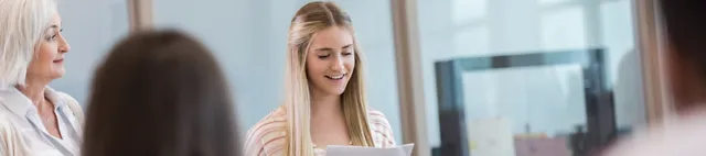 Eine Praktikantin hält vor Menschen einen Vortrag Eine Praktikantin hält vor Menschen einen Vortrag