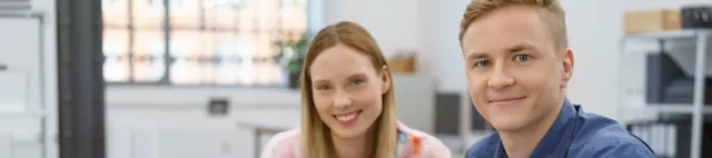 Zwei junge Menschen sitzen an einem Tisch mit Laptop Zwei junge Menschen sitzen an einem Tisch mit Laptop